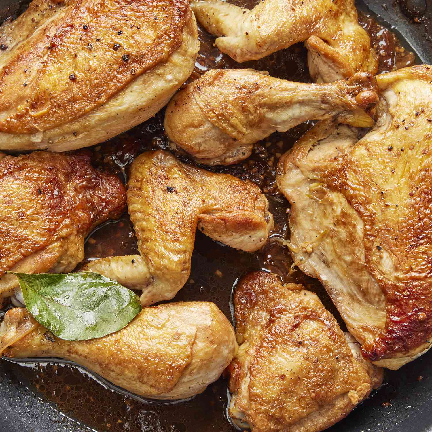 overhead view looking down at chicken adobo in a large skillet