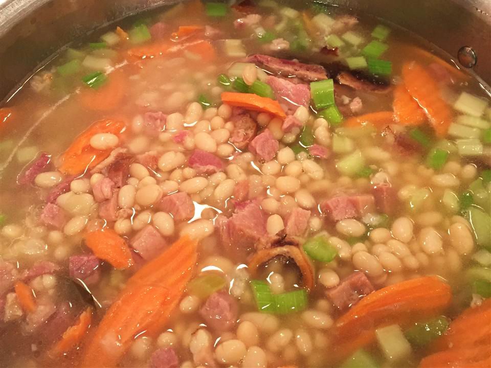 close up view of Bean Soup in a pot, beans, carrots, and pork pieces in a pot