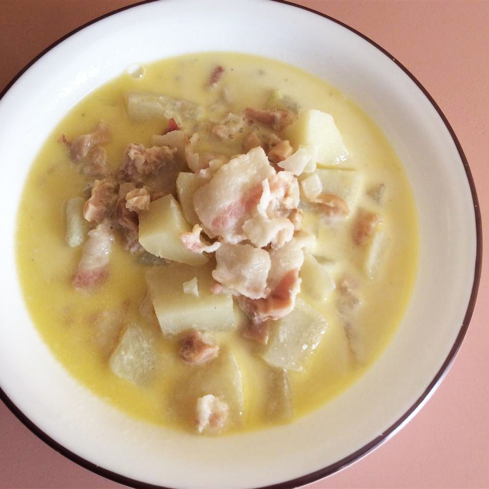 overhead view of New England Clam Chowder in a bowl, against a pink background
