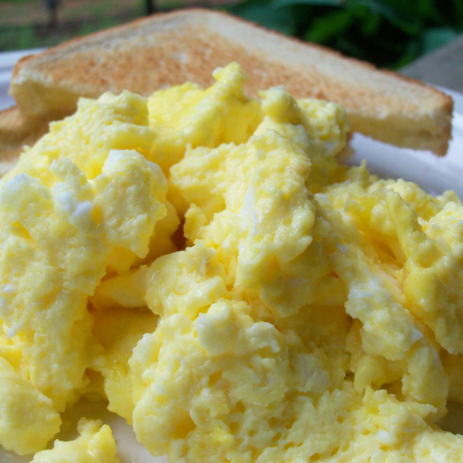 close up view of Oven Scrambled Eggs with toast in the background