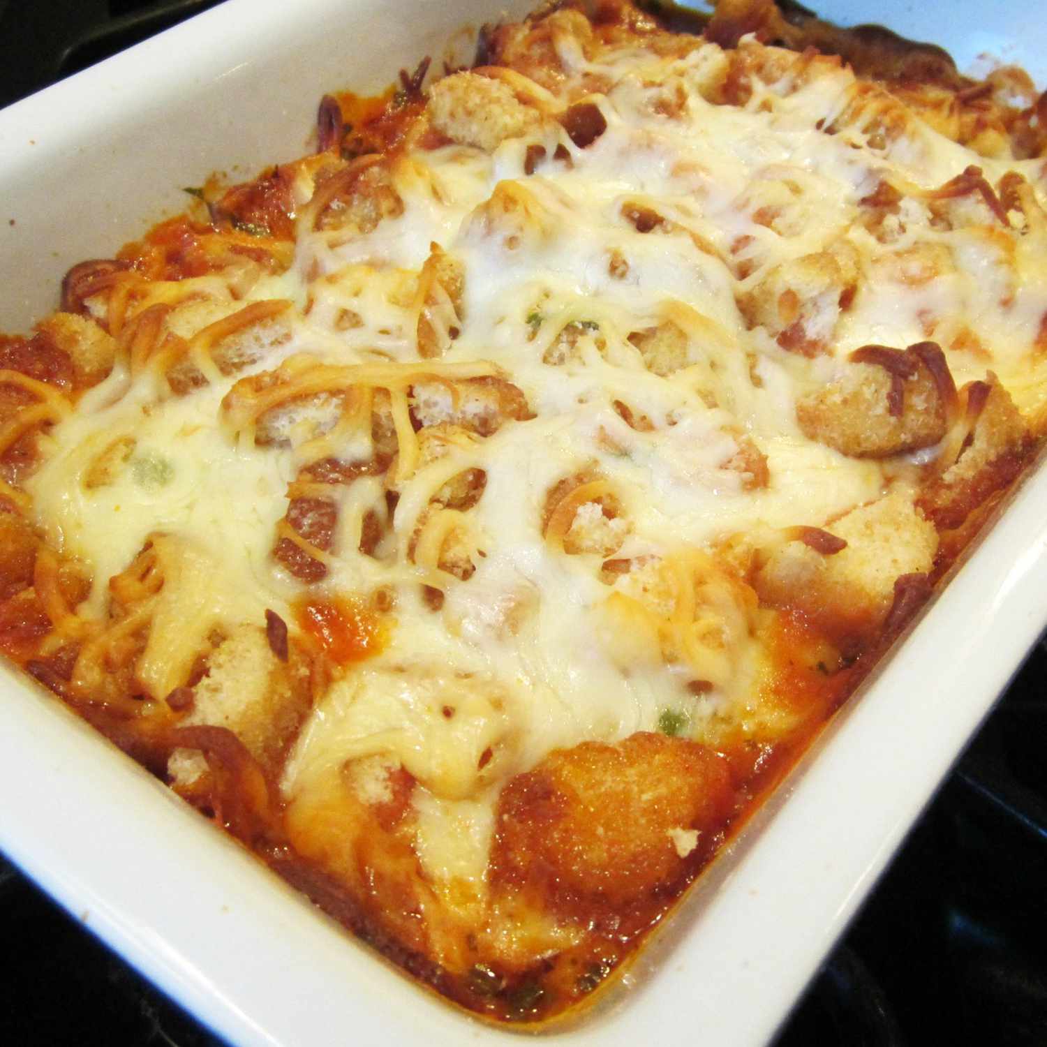 close up view of Parmesan Chicken Bake in a white baking dish
