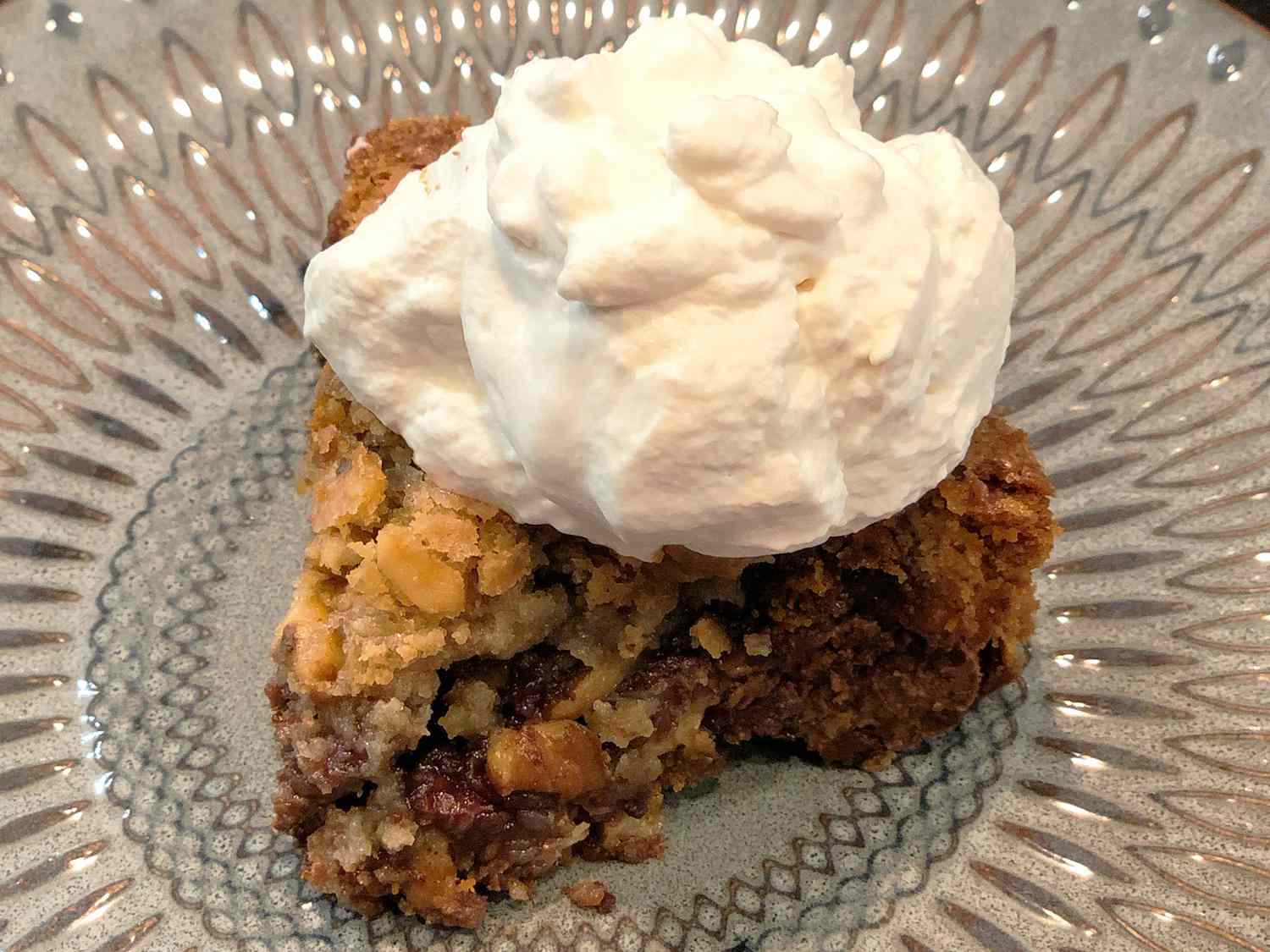 close up view of Chocolate Chip Pie garnished with whipped cream on a plate