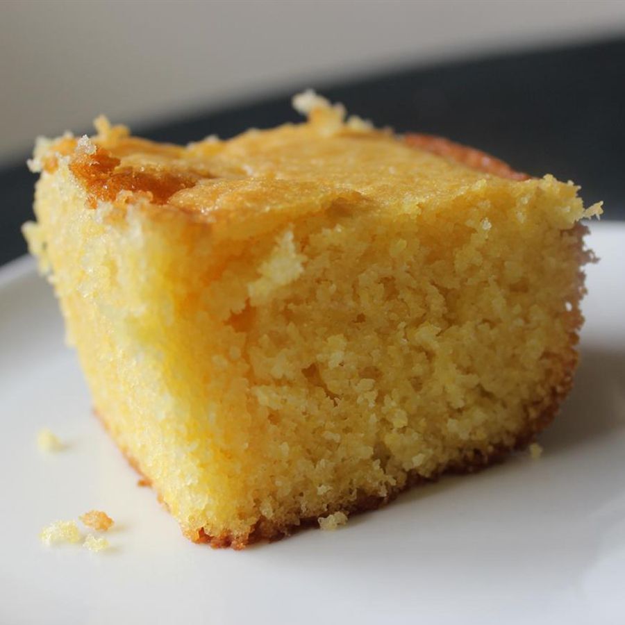 close up view of a slice of Sweet Cornbread Cake on a white plate