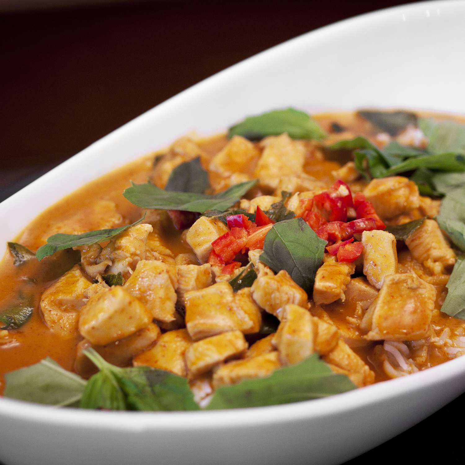 close up view of Panang Curry with Chicken in a white serving bowl