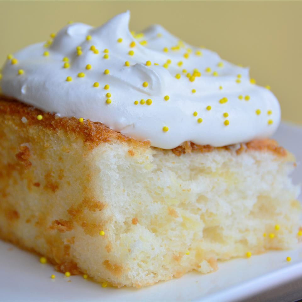 close up view of Pineapple Angel Food Cake topped with cream and yellow sprinkles