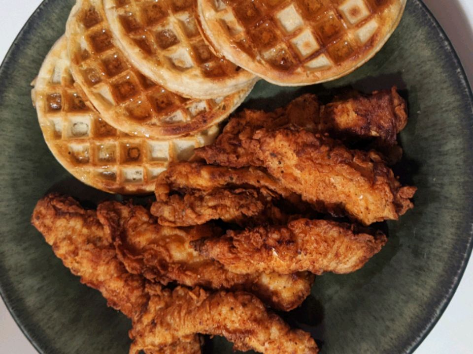 close up view of Southern Spicy Fried Chicken strips on a plate with waffles