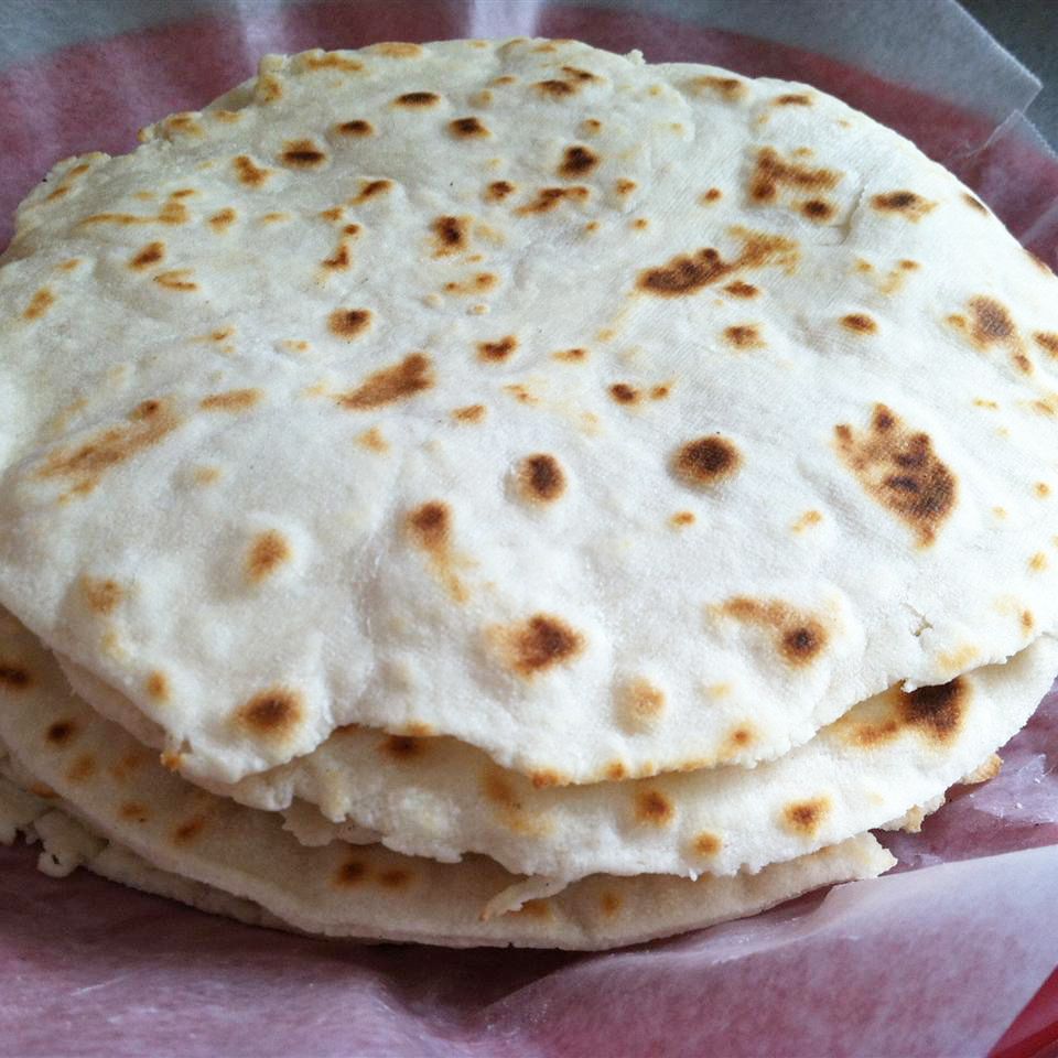 close up view of a stack of Authentic Mexican Tortillas on a parchment paper lined plate