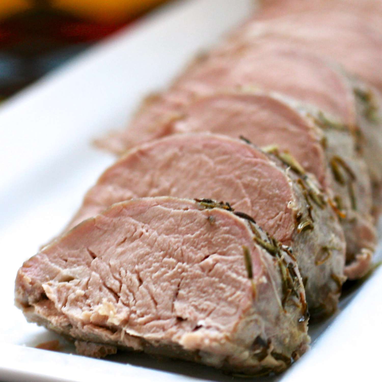 close up view of sliced pork roast on a white platter