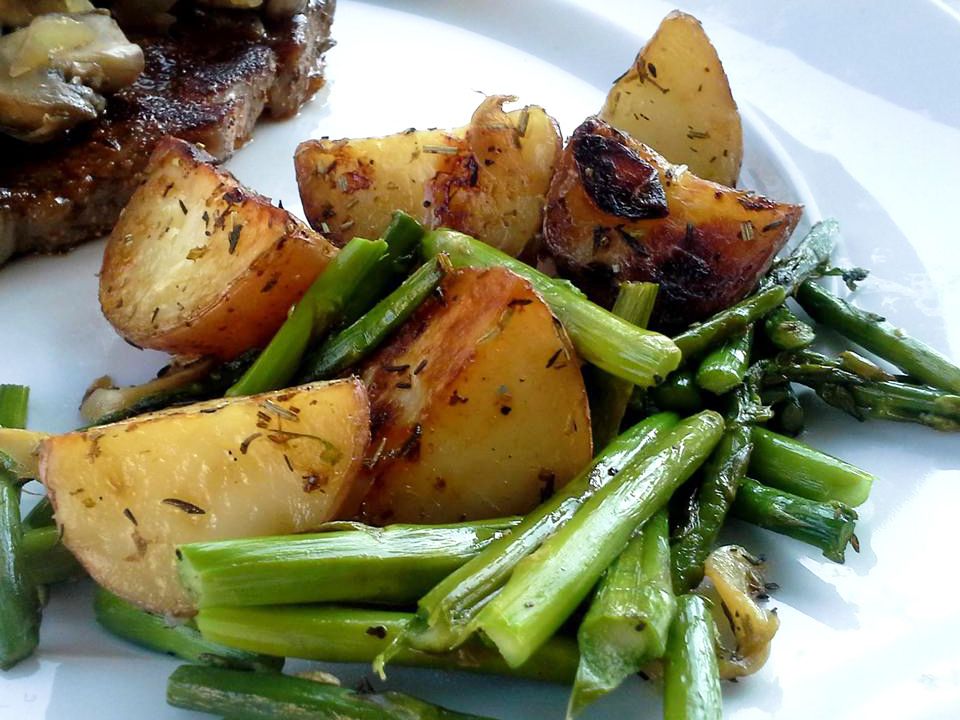 close up view of Oven Roasted Red Potatoes and Asparagus and steak on a plate