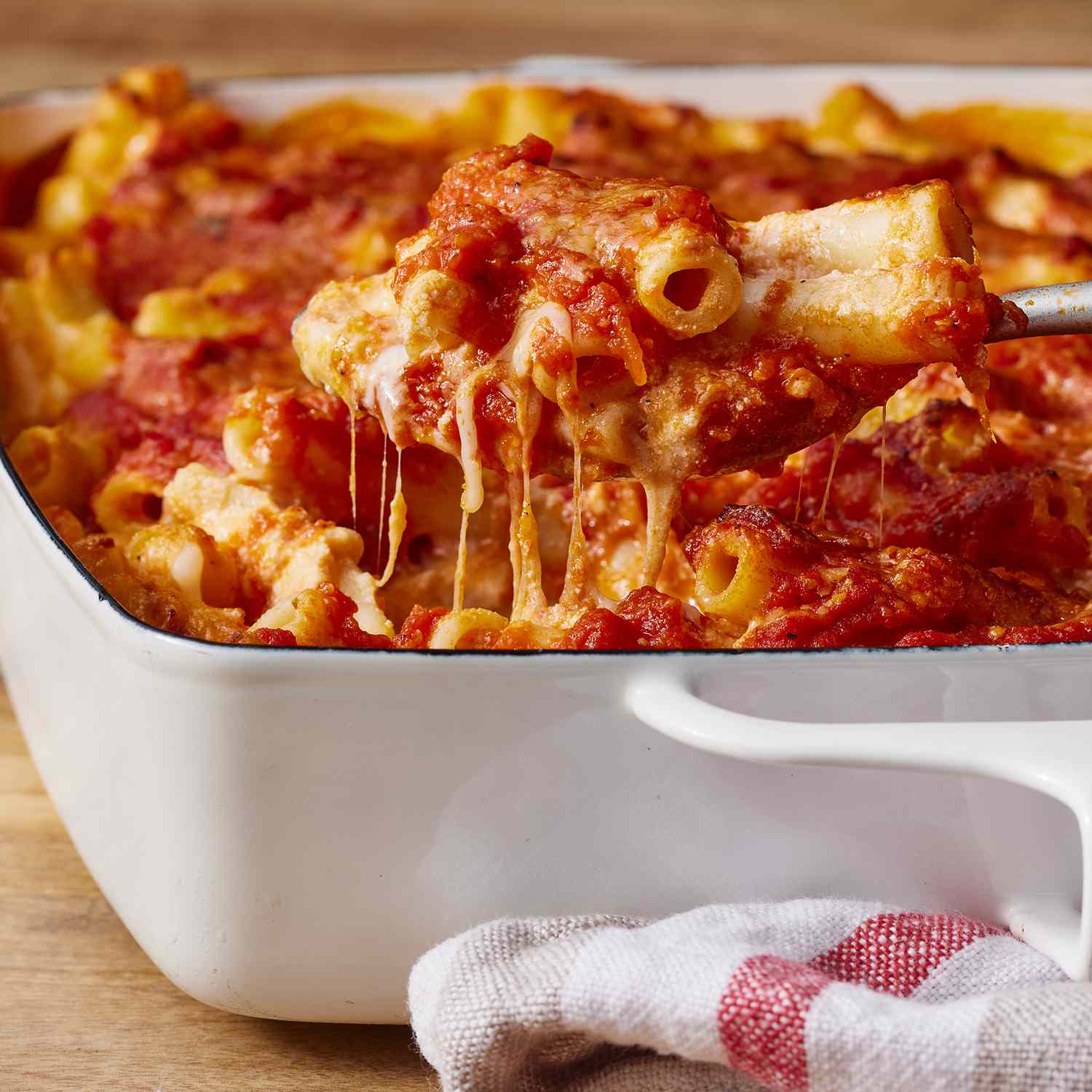 low angle looking at a baking dish of baked ziti with a spoonful coming out