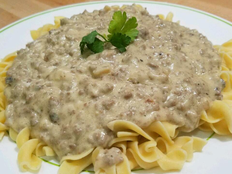 close up view of Hamburger Stroganoff garnished with fresh herbs on a white plate