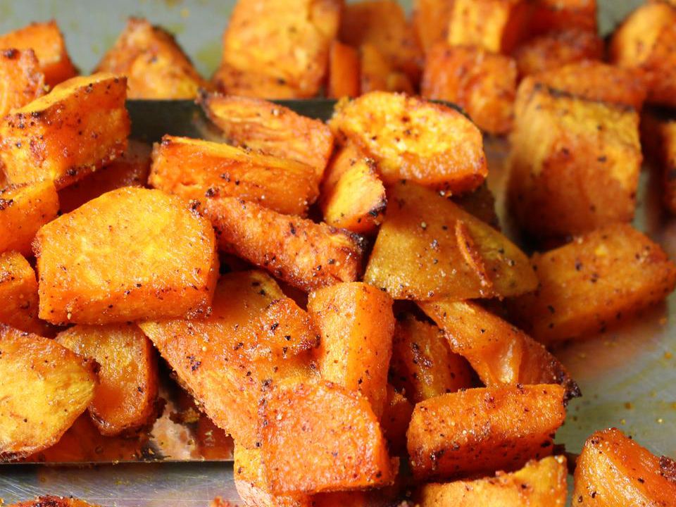 close up view of Sweet and Spicy Sweet Potatoes on a baking sheet
