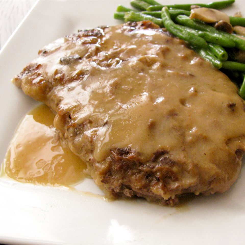 close up view of Country-Style Steak with gravy, served with green beans