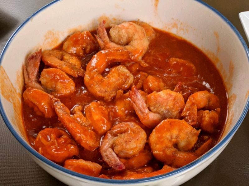 close up view of Buffalo Shrimp in a white and blue bowl