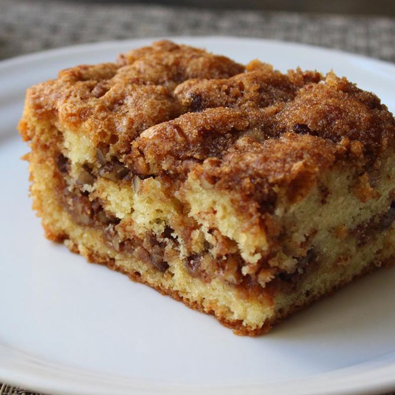 close up view of a slice of Pecan Sour Cream Coffee Cake on a white plate