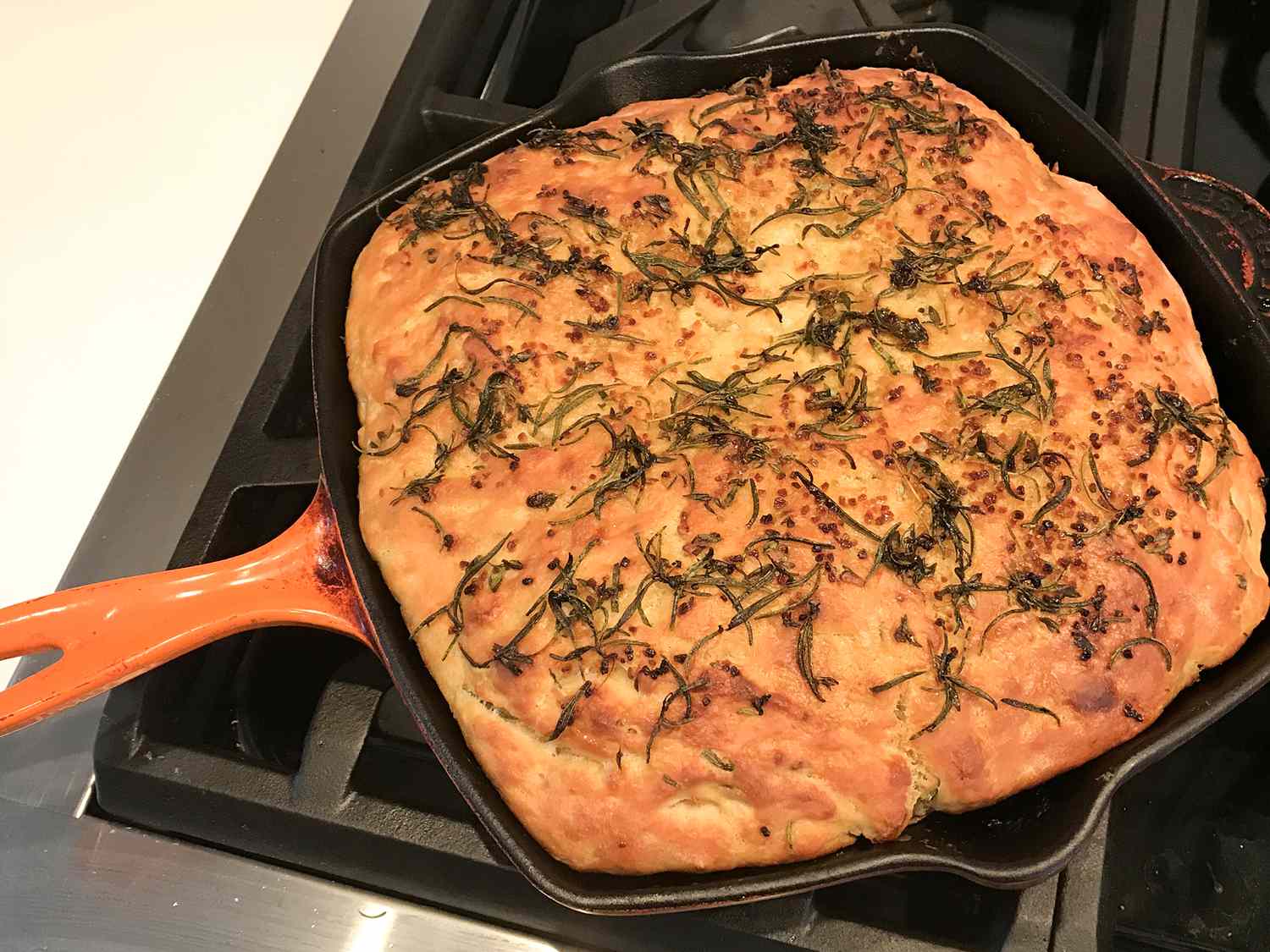 close up view of Bread Machine Focaccia in a pan on a stove