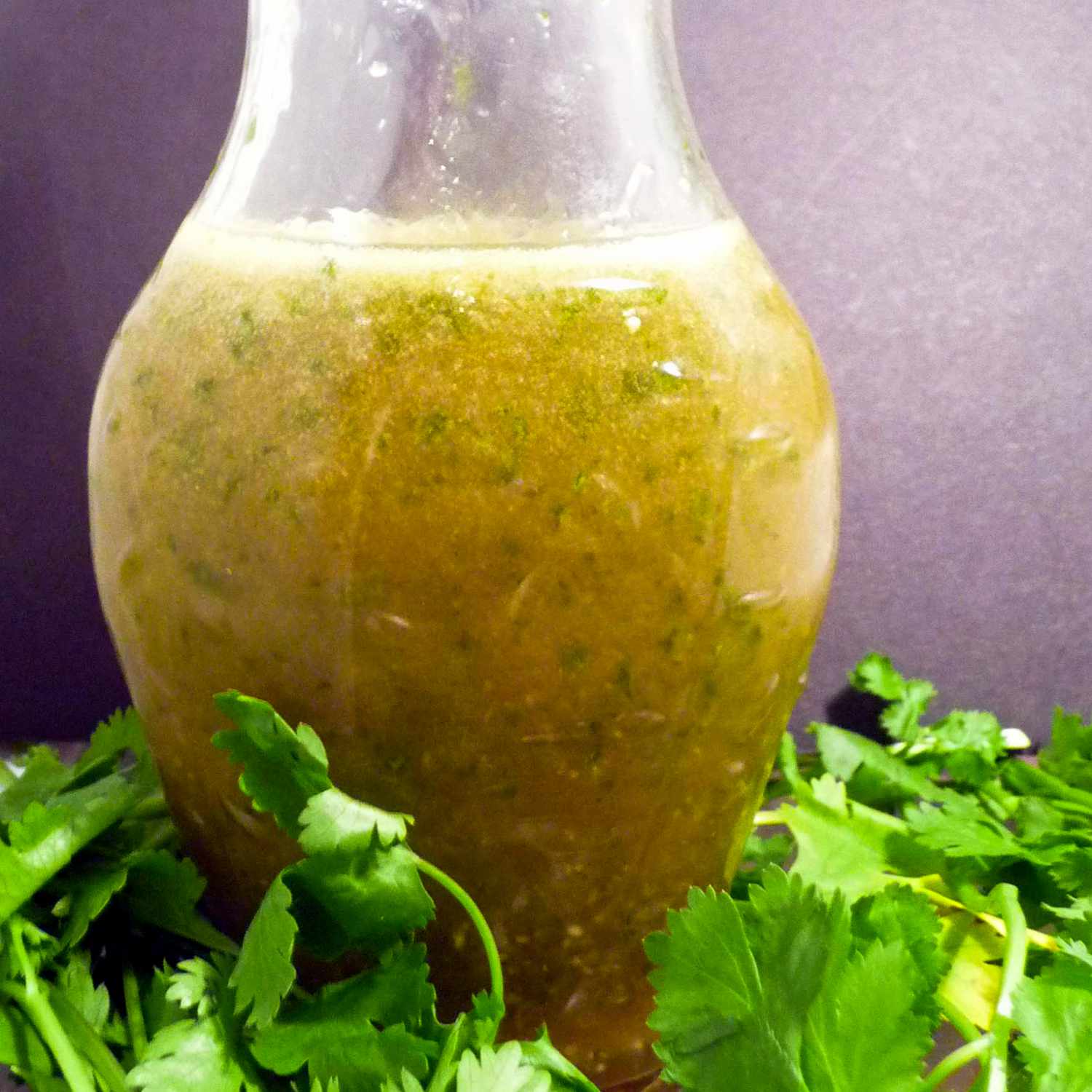 close up view of Cilantro-Lime Dressing in a bottle, next to fresh cilantro