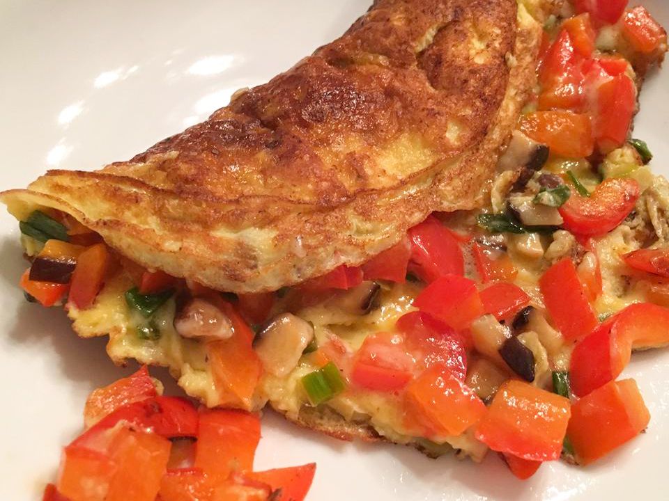 close up view of Spinach Mushroom Omelet with tomatoes on a white plate