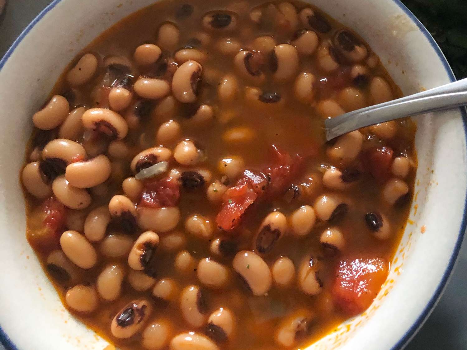 close up view of New Year Black Eyed Peas in a bowl with a spoon