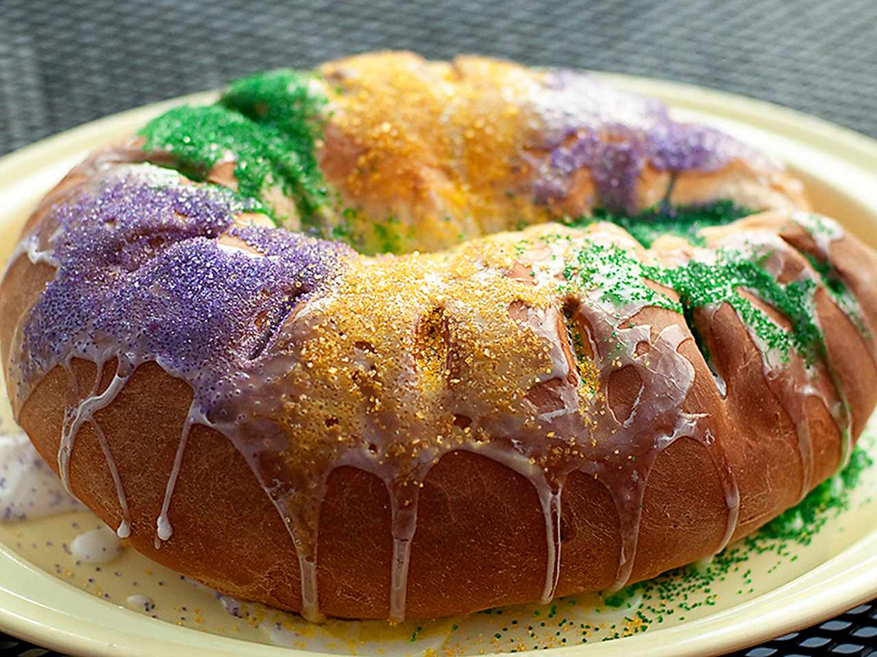 round iced cake with purple, gold, green sugars