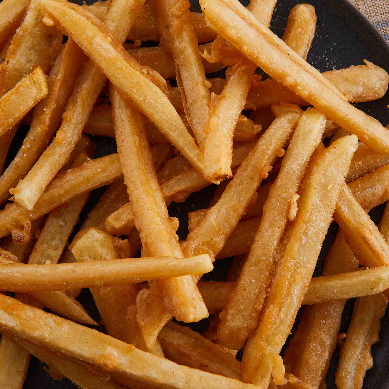 looking down at a large bowl of crispy, golden brown french fries