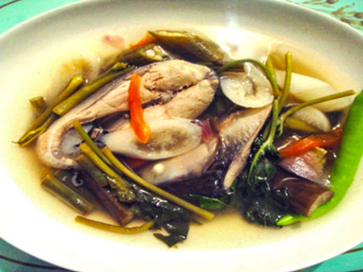 close up view of Sinigang na Bangus (Filipino Milkfish in Tamarind Broth) in a white bowl