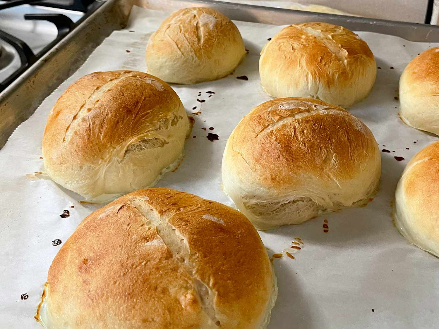 close up view of German Brotchen Rolls on a parchment paper lined baking sheet