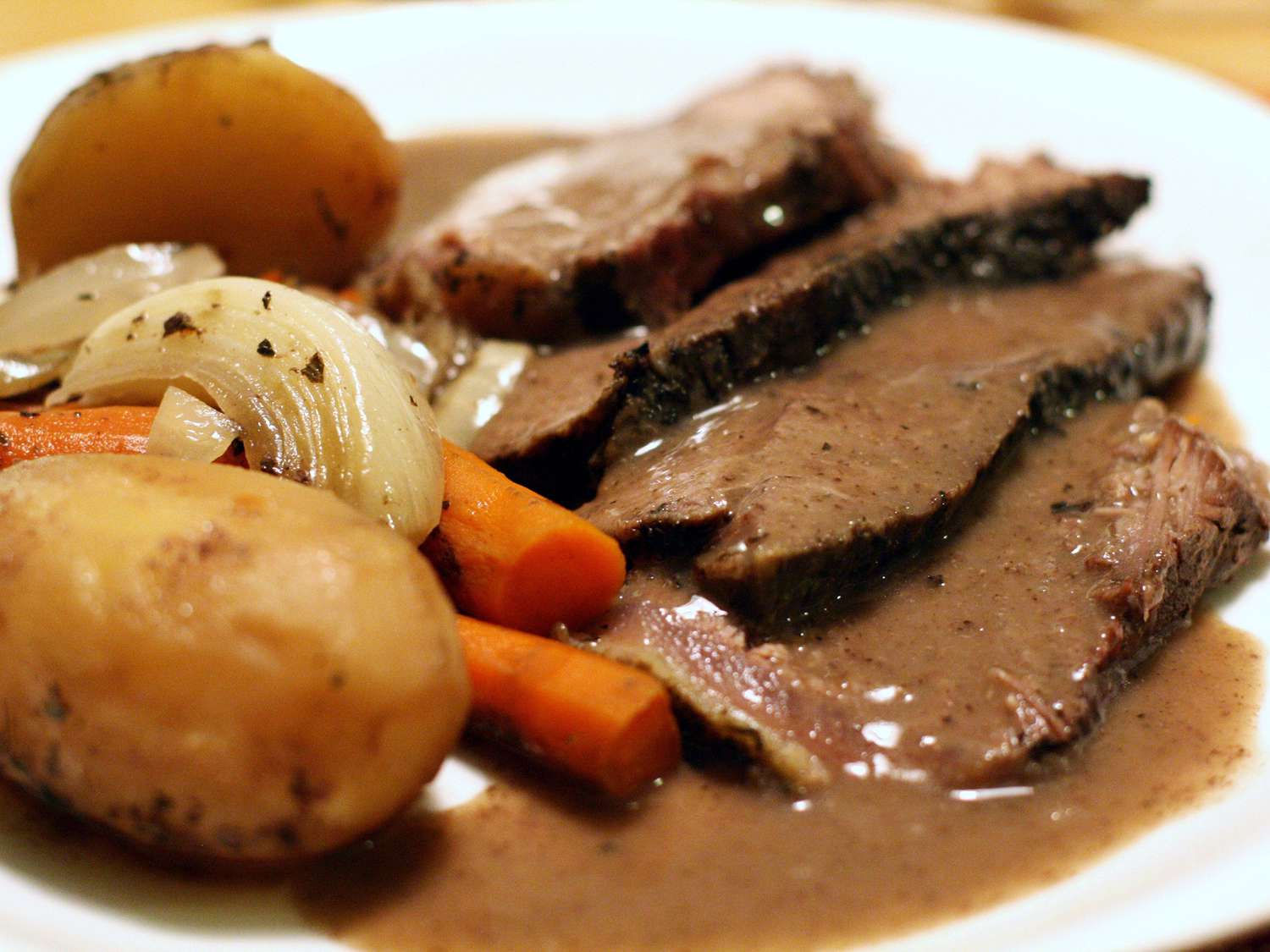 close up view of sliced Red Wine Pot Roast with potatoes, carrots, and onions