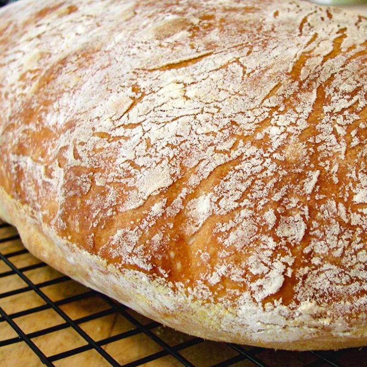 close up view of a loaf of Ciabatta bread on a cooling rack