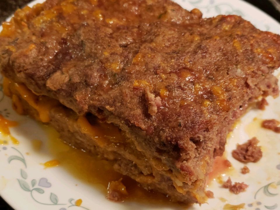 close up view of a Cheesy Meatloaf on a white platter