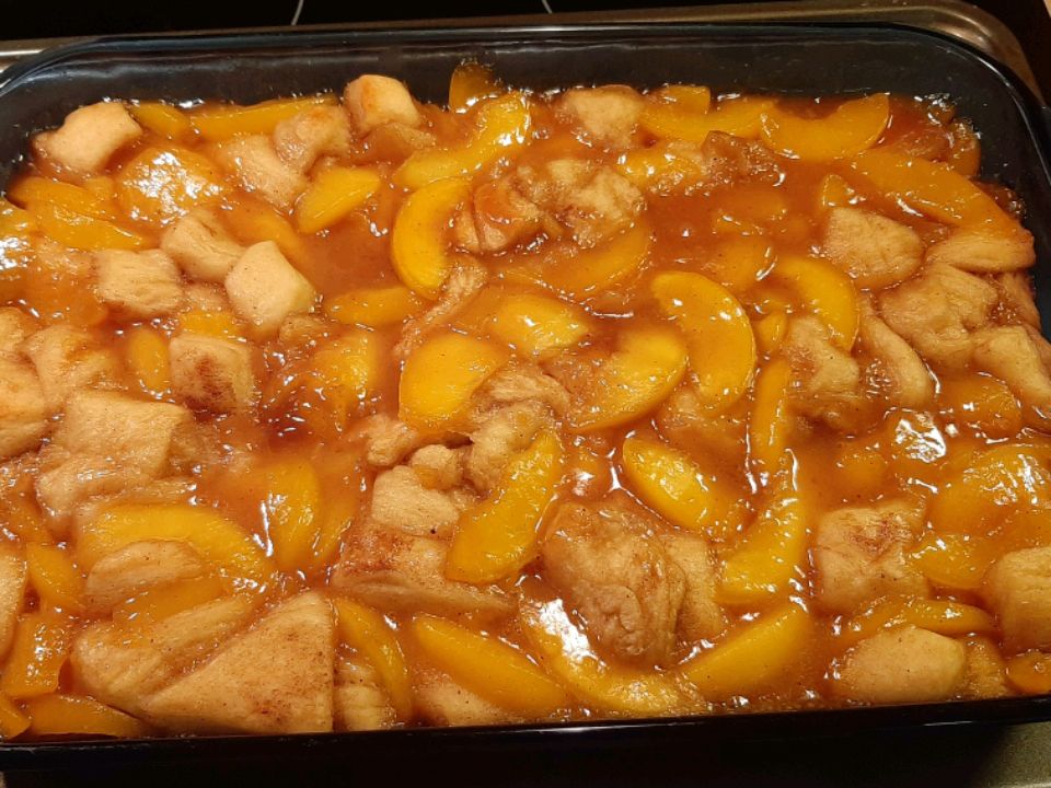 close up view of Butter Biscuit Peach Cobbler in a baking dish