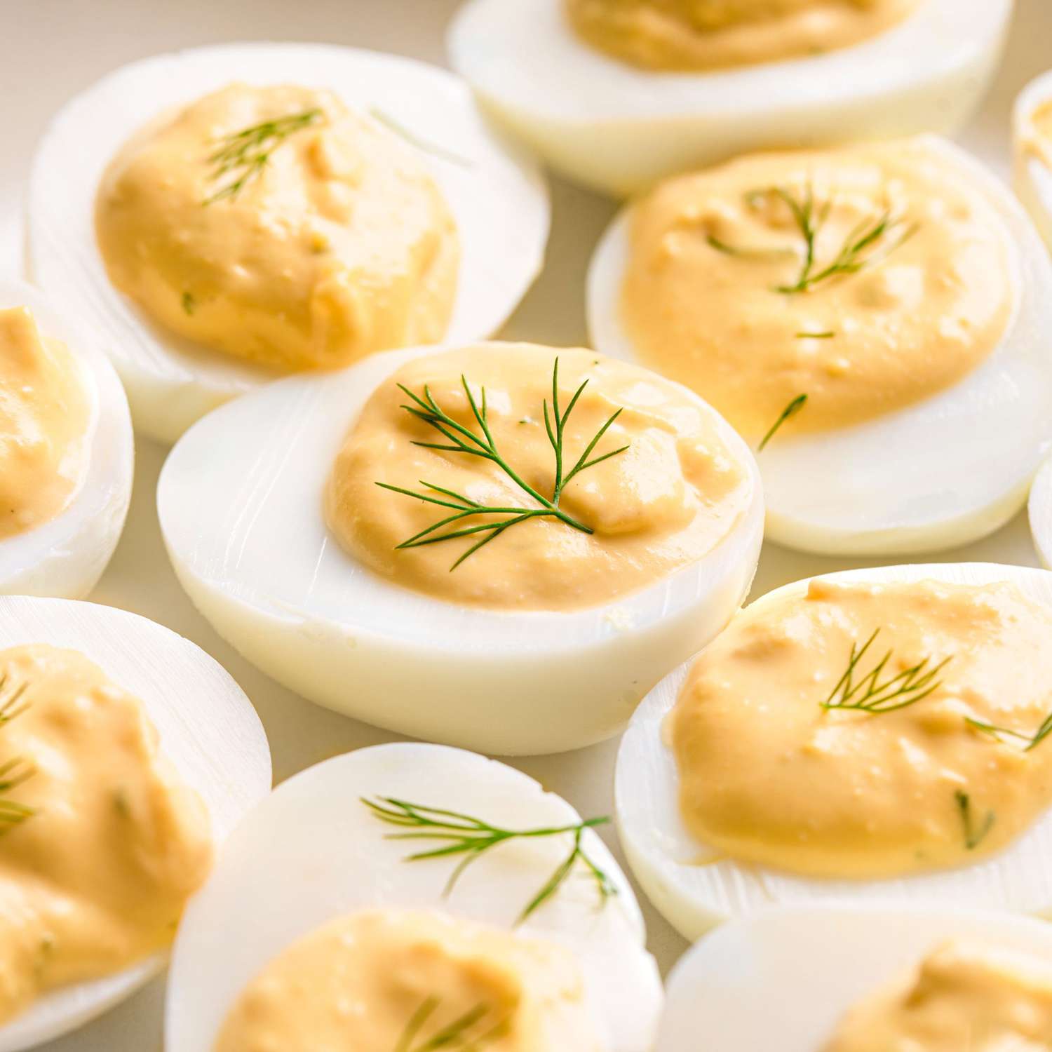 a super close up view of several savory deviled eggs topped with fresh dill.