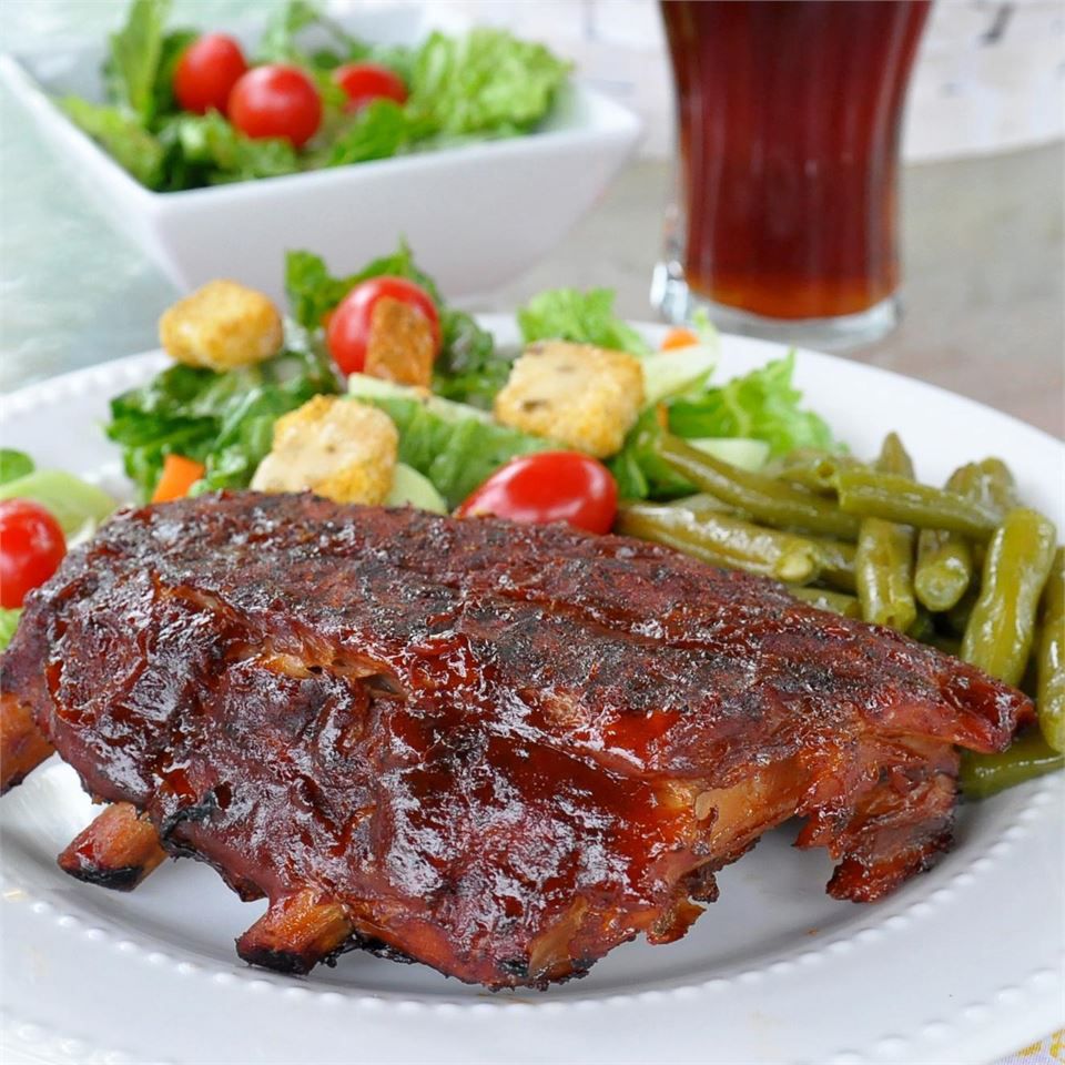 rack of ribs on a plate with colorful salad