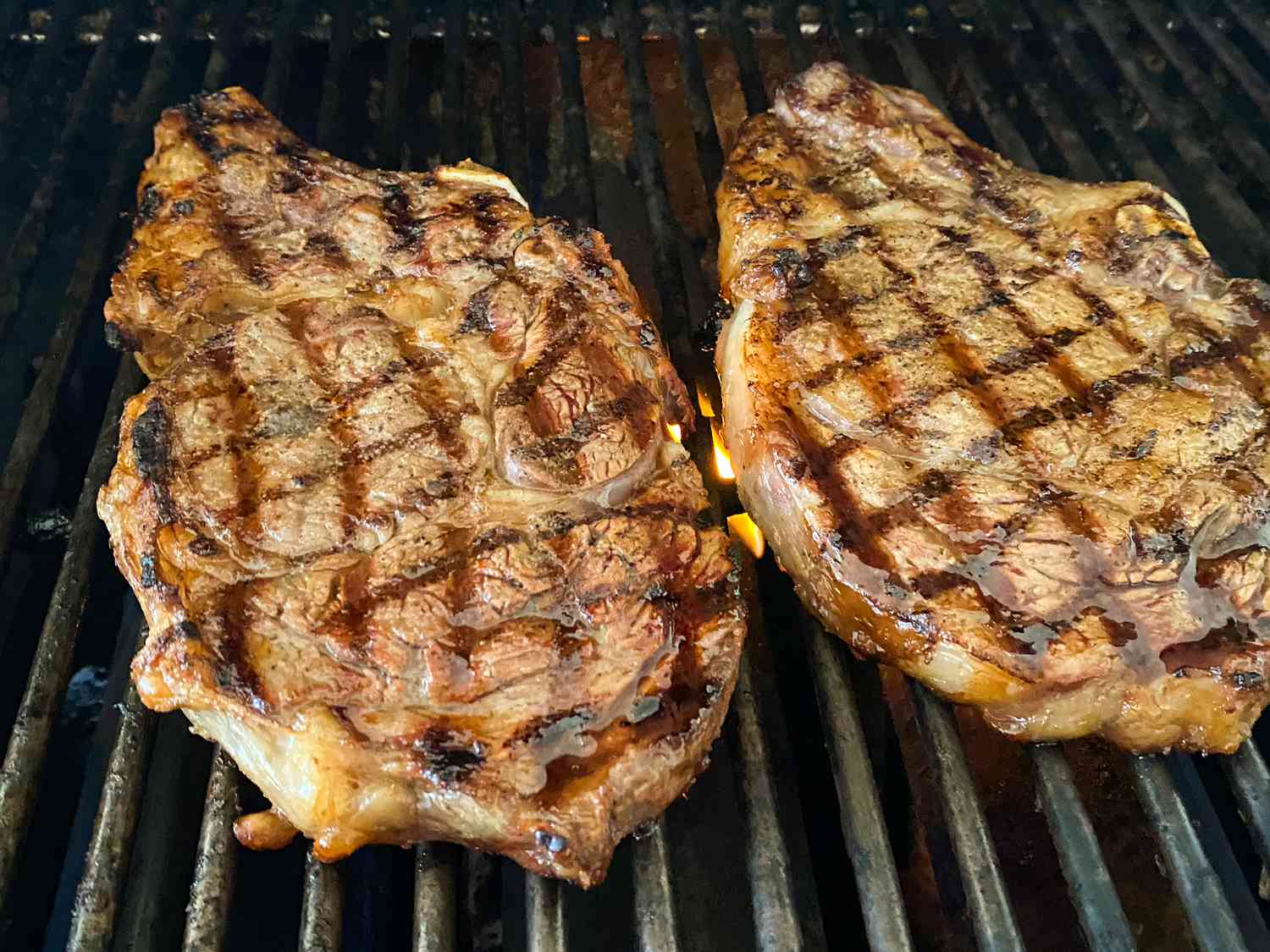 close up view of two Bourbon Street Rib-Eye Steaks on a grill