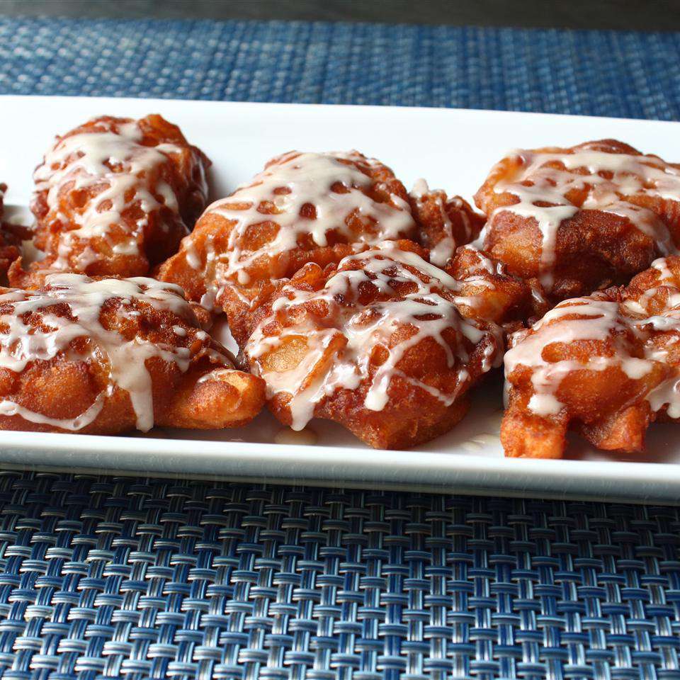 close up view of Apple Fritters with icing on a white platter