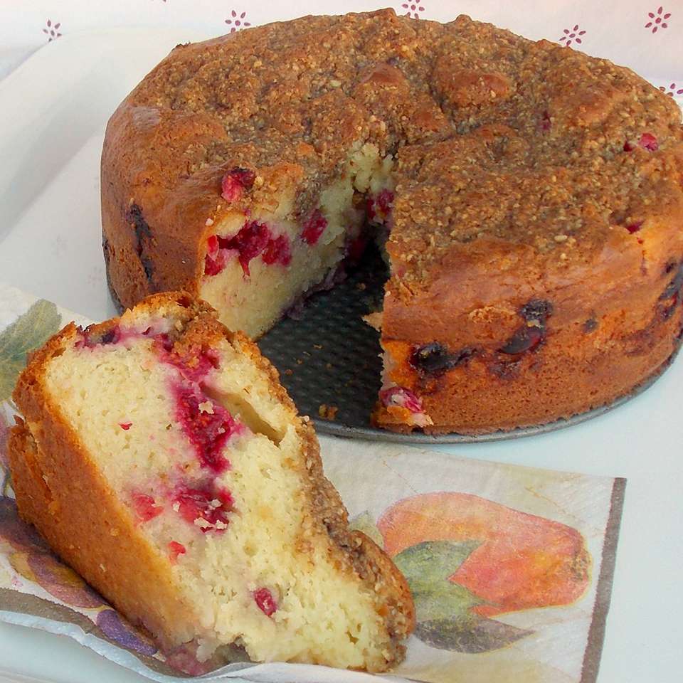 round sour cream cranberry cake with one slice plated