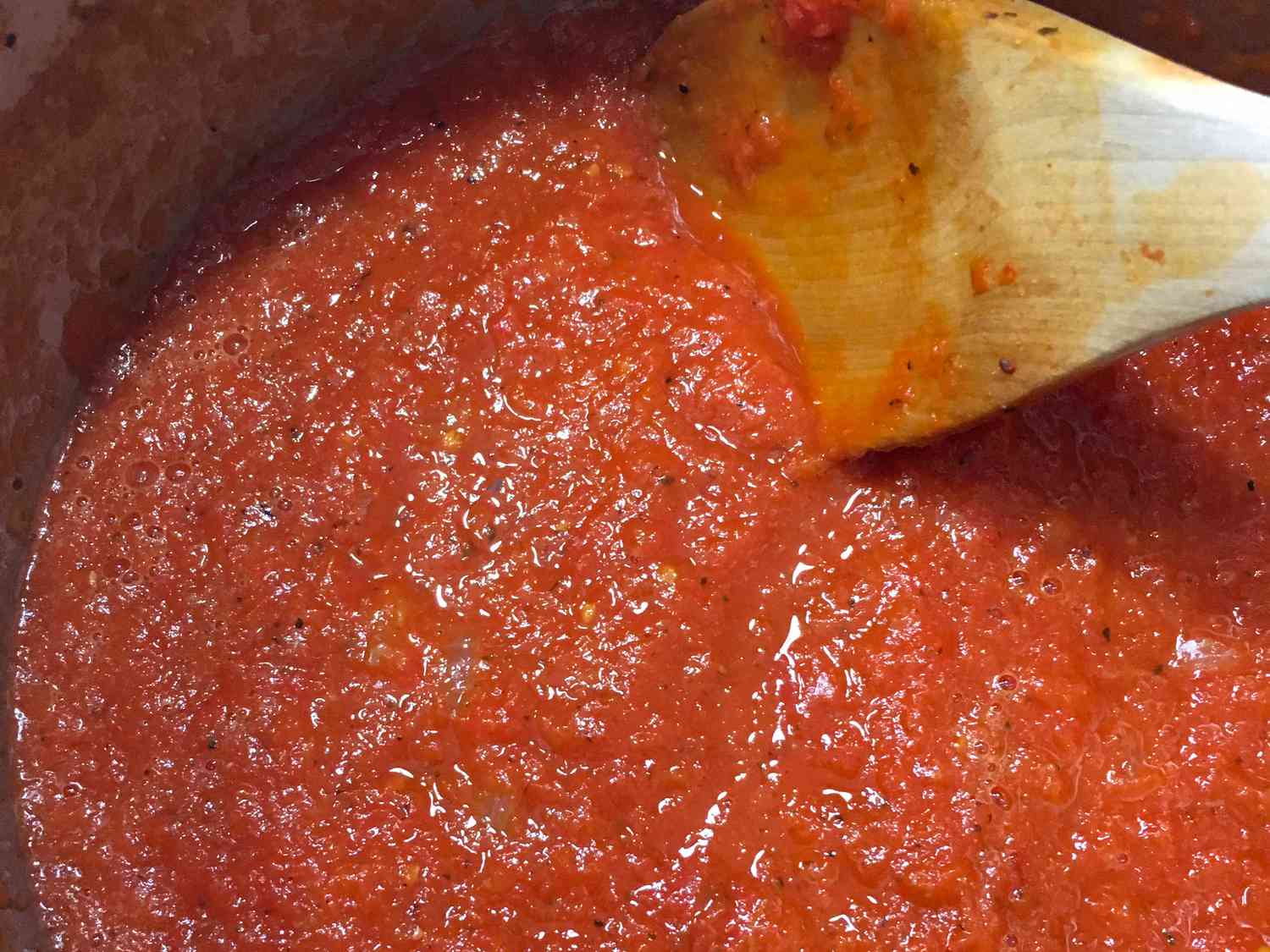close up view of Spaghetti Sauce from Fresh Tomatoes in a pot with a wooden spoon