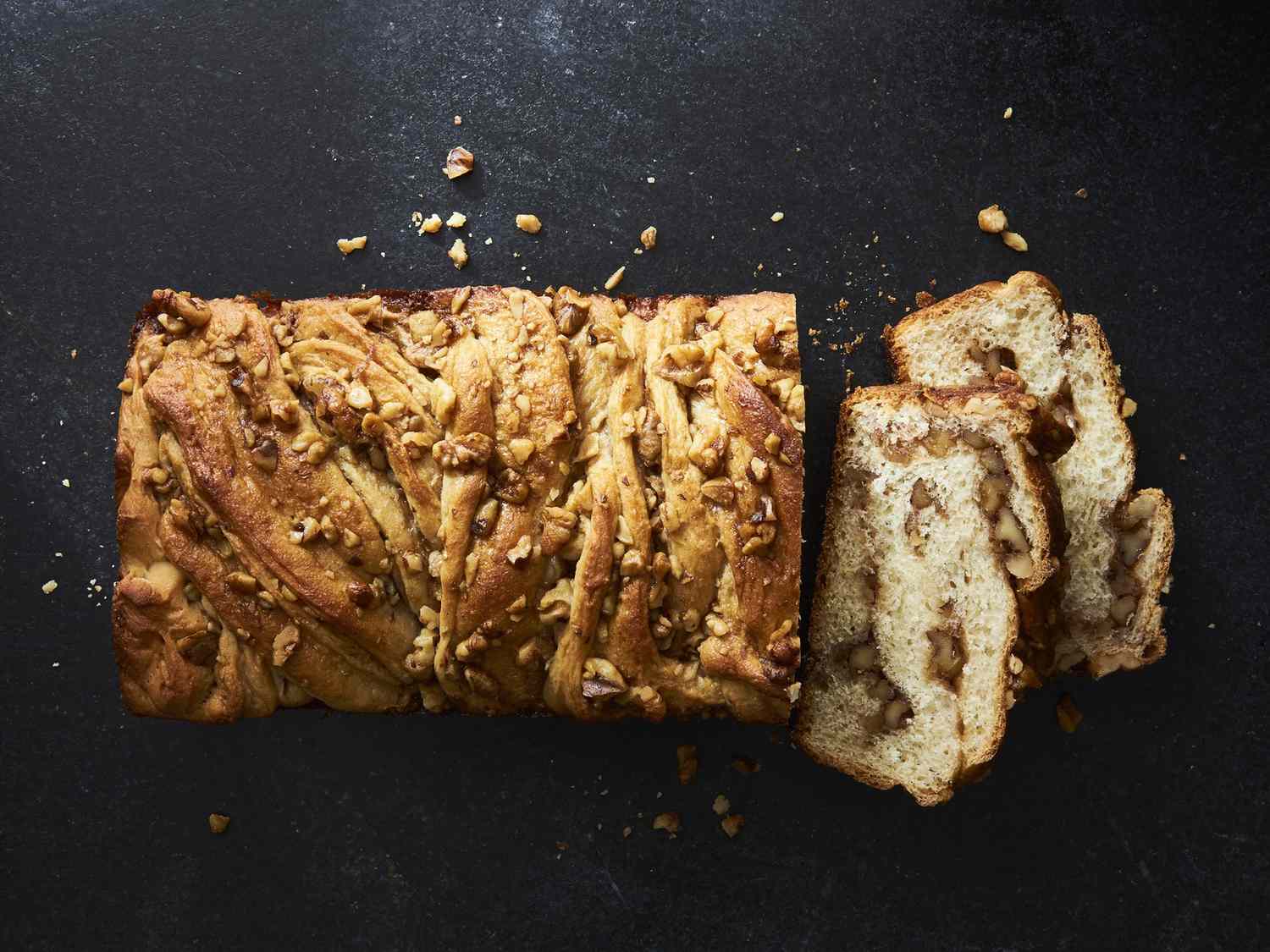 close up view of a sliced Babka with nuts on a black surface