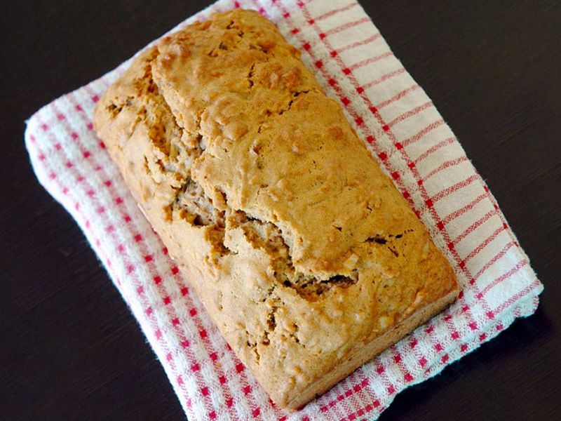 close up view of a loaf of Pear Bread on a red and white kitchen towel