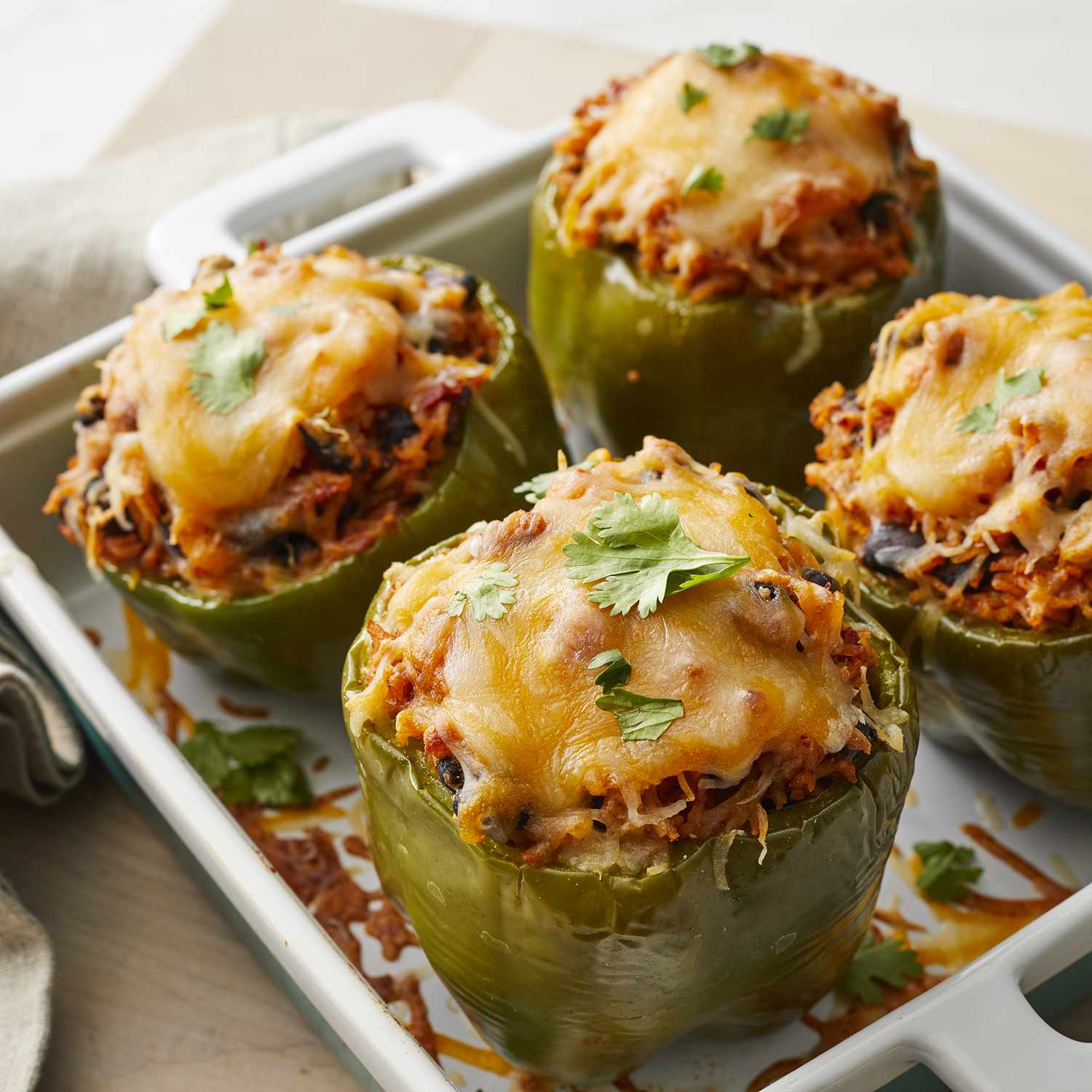 high angle looking at a casserole dish of four vegetarian Mexican inspired stuffed peppers
