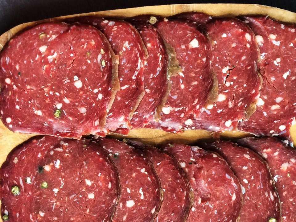 close up view of sliced Venison Salami on a wooden board