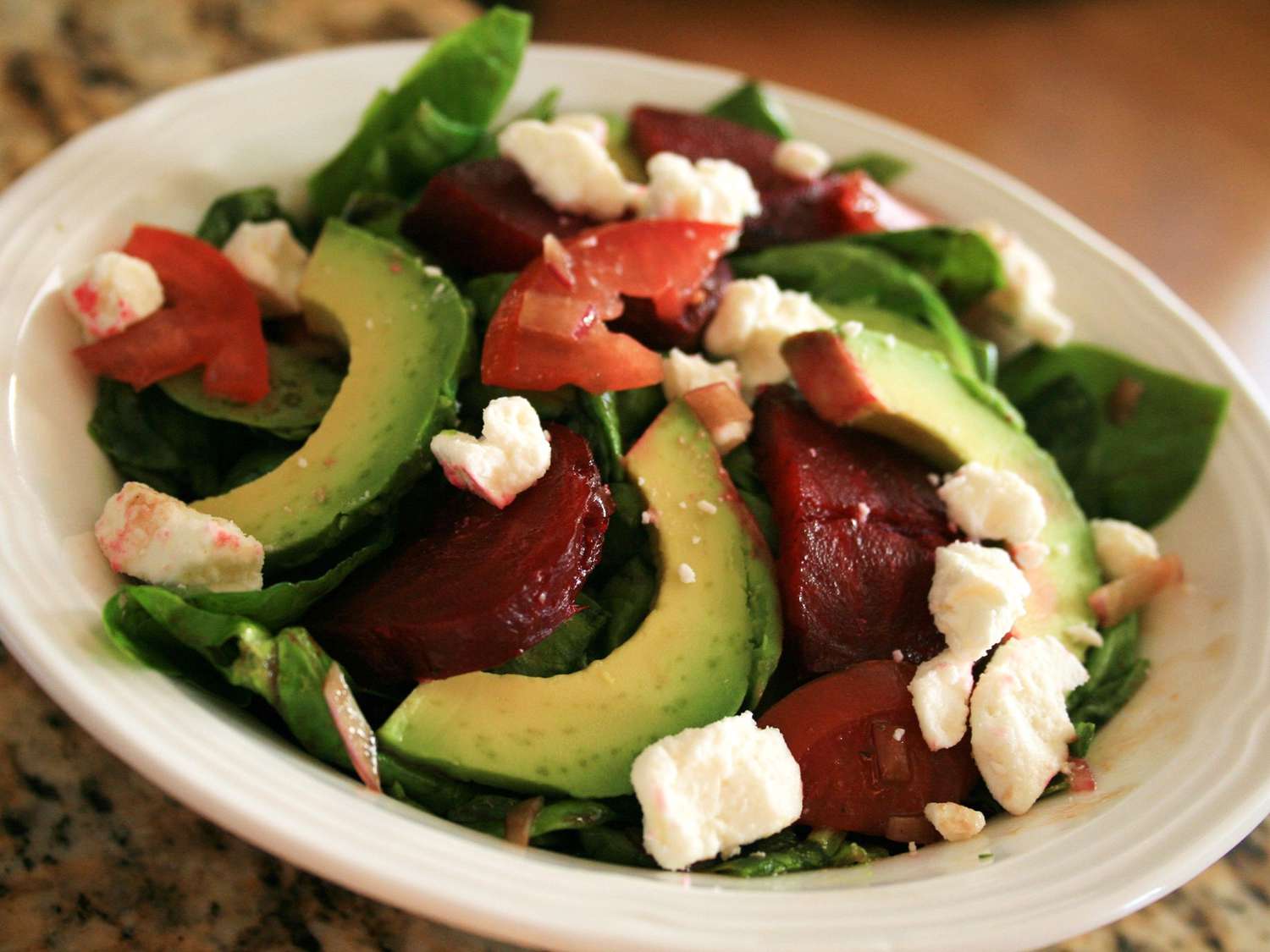close up view of Beet Salad with avocado, cheese, lettuce and tomato on a platter