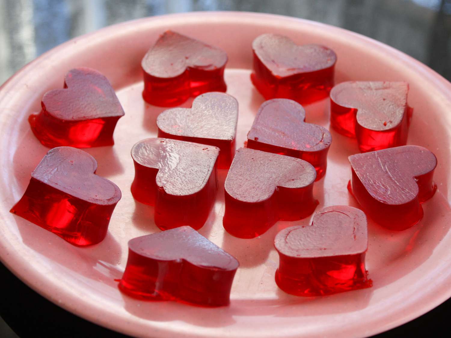 close up view of heart shaped gelatin on a pink platter