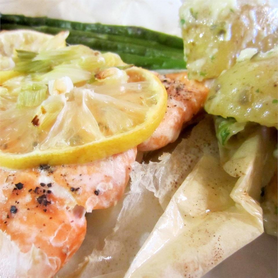 close up view of a fillet of Salmon En Papillote with lemon and herbs, served with green beans