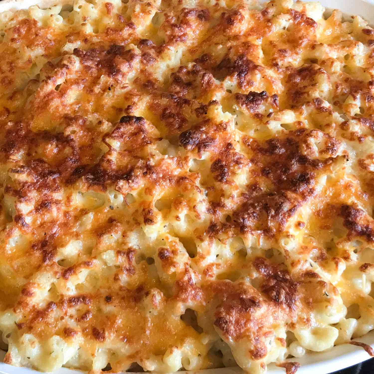 close up view of Five-Cheese Baked macaroni and cheese in a white baking dish