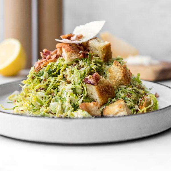 side view of a shallow bowl piled high with Caesar salad
