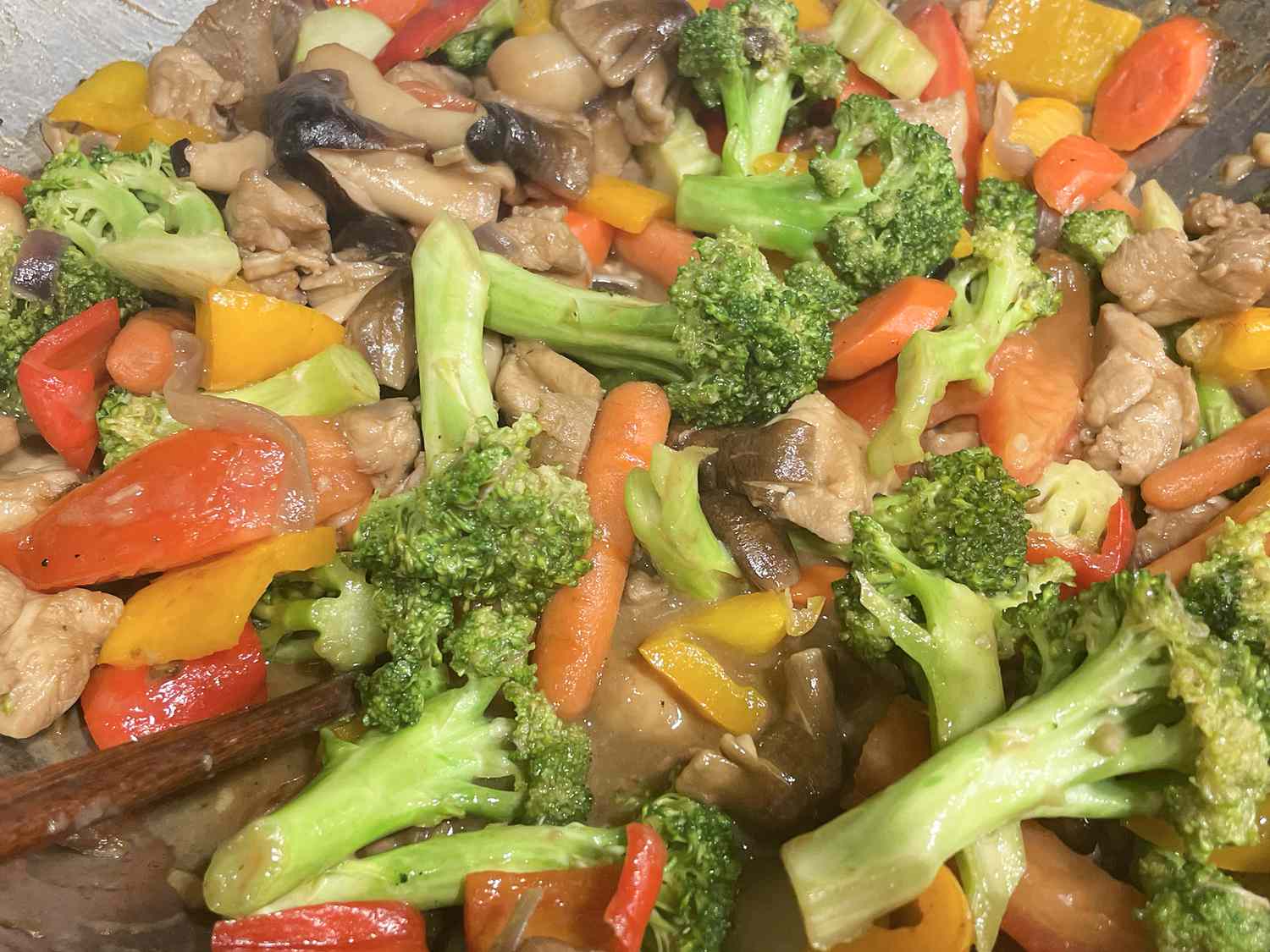 close up view of Chicken and Chinese Vegetable Stir-Fry, including broccoli, peppers, carrots and mushrooms in a pan