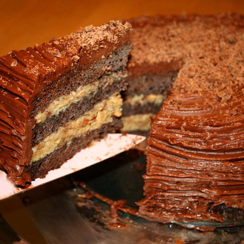 close up view of a sliced German Chocolate Cake, with a slice of cake on a cake server