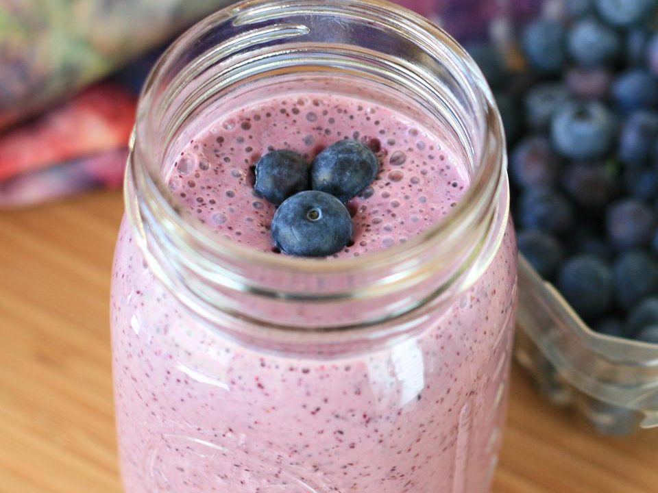 close up view of a Blueberry Breakfast Smoothie garnished with blueberries in a jar