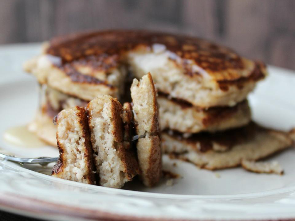 close up view of a stack of Almond Flour Pancakes with butter, and pancakes on a fork